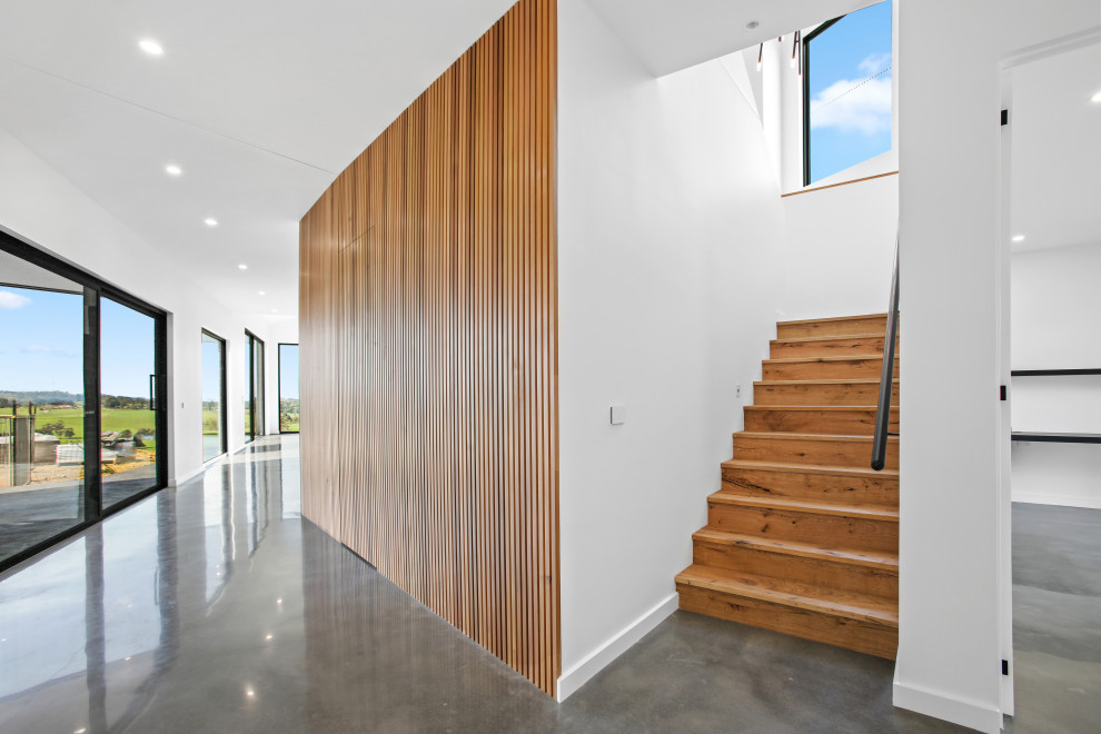 Inspiration for a large modern wood u-shaped staircase with wood risers and metal railing.