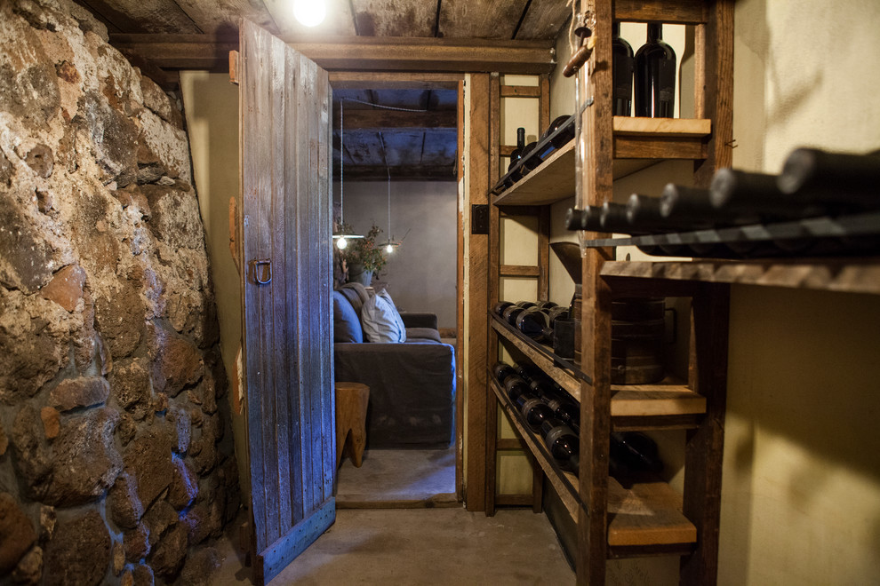 Small country wine cellar in San Francisco with concrete floors and storage racks.