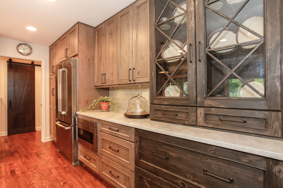 Mid-sized country galley eat-in kitchen in Chicago with an undermount sink, recessed-panel cabinets, medium wood cabinets, marble benchtops, grey splashback, ceramic splashback, stainless steel appliances, medium hardwood floors and with island.