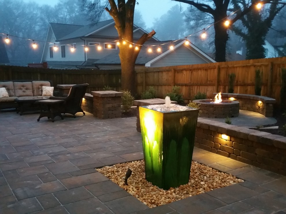This is an example of a large arts and crafts backyard patio in Atlanta with a fire feature, natural stone pavers and no cover.