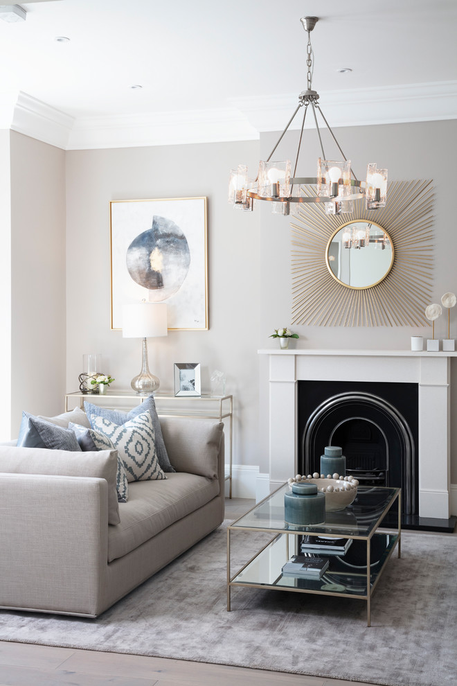Transitional living room in London with beige walls, a standard fireplace and beige floor.
