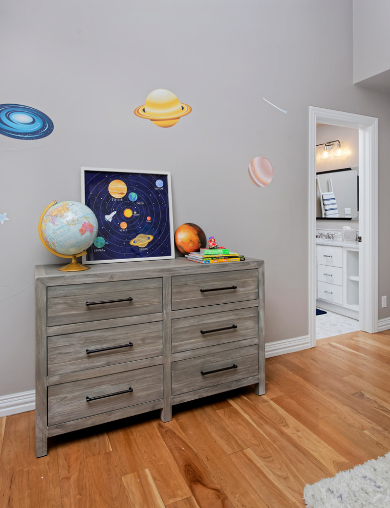 This is an example of a medium sized contemporary gender neutral kids' bedroom in Other with beige walls and medium hardwood flooring.