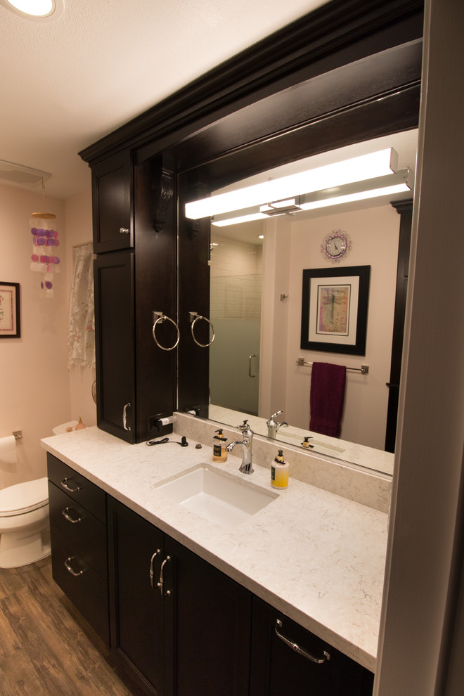 Example of a mid-sized transitional master white tile and subway tile brown floor bathroom design with flat-panel cabinets, dark wood cabinets, a two-piece toilet, pink walls, an undermount sink and quartz countertops