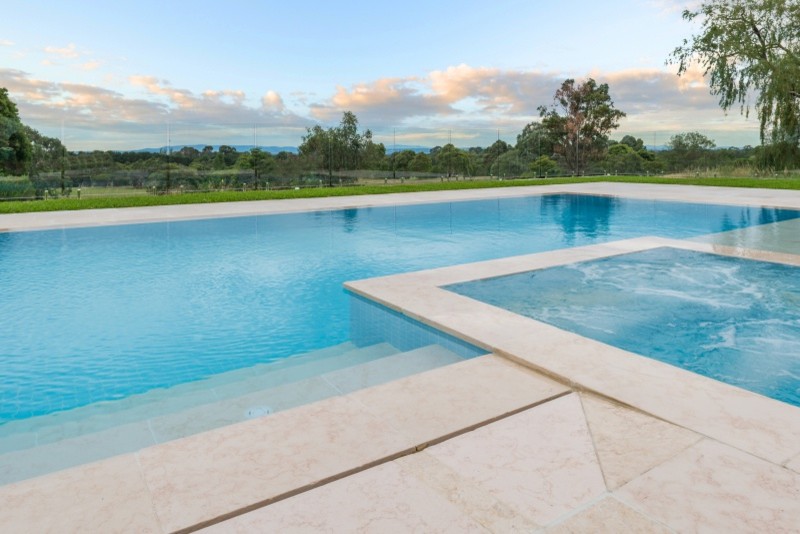 This is an example of a modern backyard custom-shaped pool in Gold Coast - Tweed with natural stone pavers.