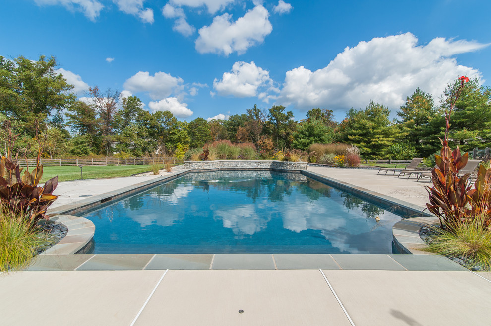 Design ideas for an expansive traditional backyard rectangular pool in Philadelphia with a water feature and decking.