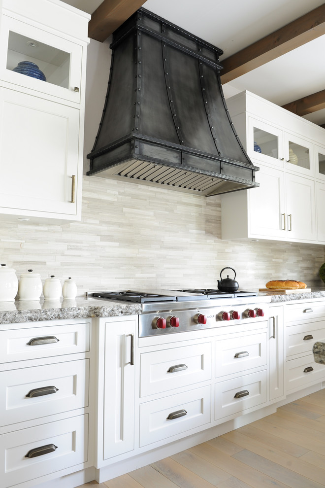 Inspiration for an expansive transitional u-shaped eat-in kitchen in Vancouver with a farmhouse sink, glass-front cabinets, grey cabinets, granite benchtops, grey splashback, stone tile splashback, stainless steel appliances, light hardwood floors and with island.