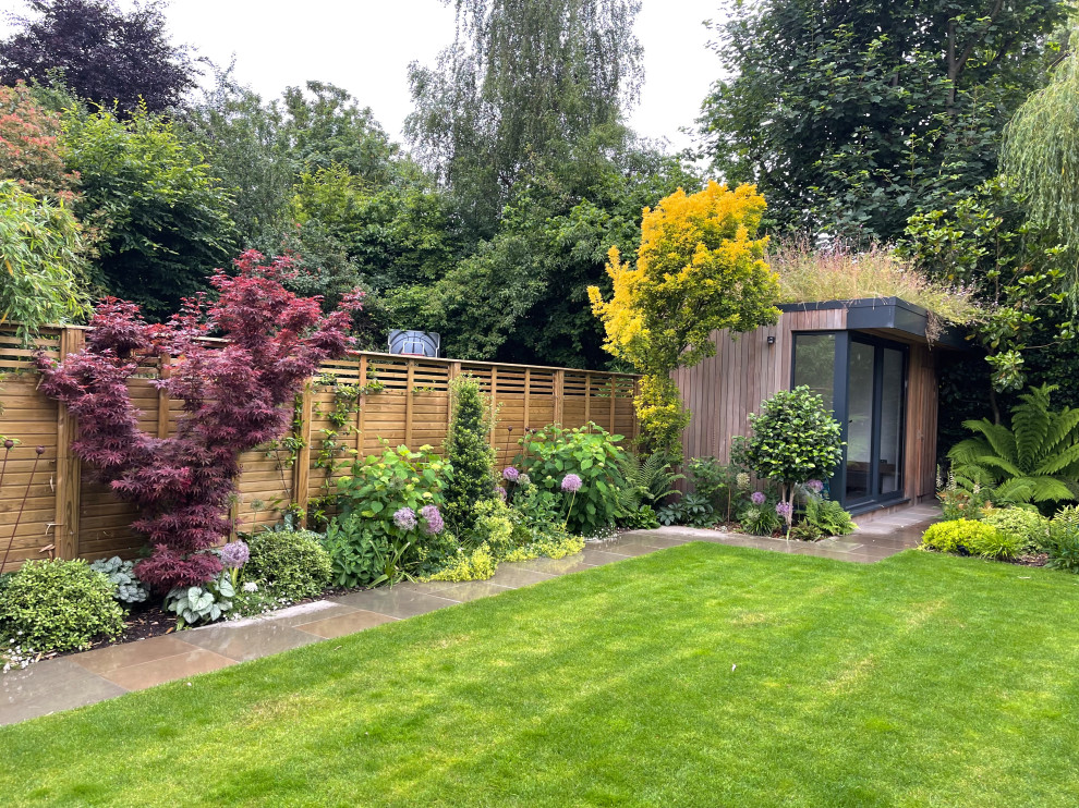 Свежая идея для дизайна: большой солнечный, летний регулярный сад на заднем дворе в современном стиле с хорошей освещенностью, покрытием из каменной брусчатки и с деревянным забором - отличное фото интерьера