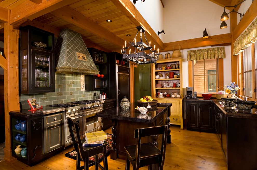 Photo of a mid-sized country u-shaped separate kitchen in Chicago with an undermount sink, beaded inset cabinets, black cabinets, granite benchtops, green splashback, stone tile splashback, panelled appliances, dark hardwood floors, with island and brown floor.
