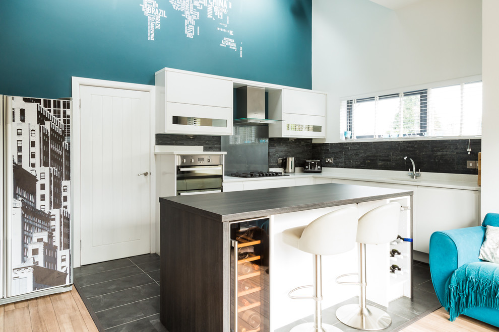 Photo of a mid-sized contemporary l-shaped open plan kitchen in Other with an undermount sink, flat-panel cabinets, white cabinets, quartzite benchtops, grey splashback, glass sheet splashback, stainless steel appliances and with island.