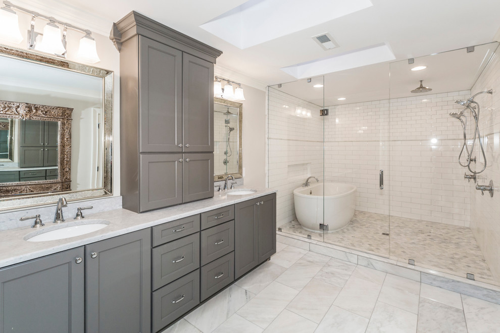 Design ideas for a mid-sized transitional master bathroom in Other with shaker cabinets, grey cabinets, a freestanding tub, a shower/bathtub combo, stone tile, grey walls, marble floors, an undermount sink and marble benchtops.