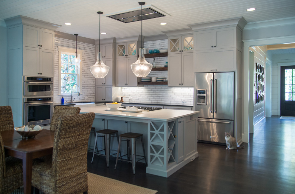 This is an example of a large country l-shaped separate kitchen in Atlanta with shaker cabinets, grey cabinets, quartz benchtops, white splashback, subway tile splashback, stainless steel appliances, dark hardwood floors and with island.