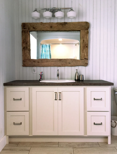 Inspiration for a mid-sized transitional 3/4 porcelain tile and beige floor tub/shower combo remodel with shaker cabinets, white cabinets, white walls, a drop-in sink, wood countertops and brown countertops
