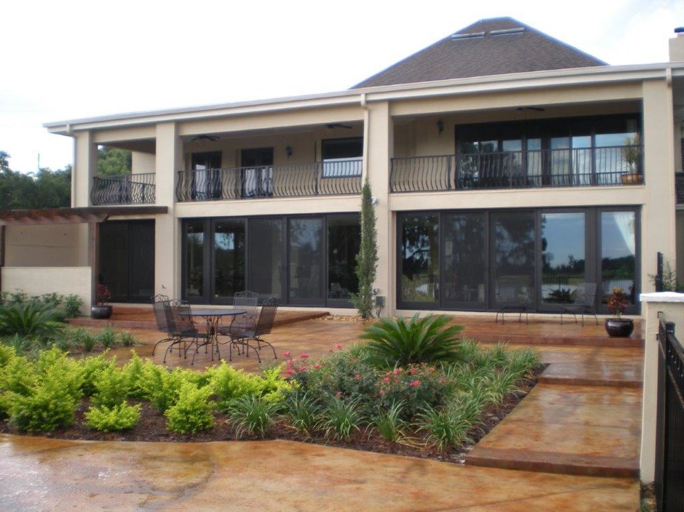 Inspiration for a mid-sized traditional backyard patio in Orlando with a water feature, stamped concrete and an awning.