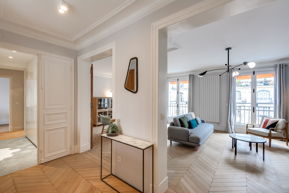 Photo of a mid-sized transitional foyer in Paris with grey walls, light hardwood floors, a double front door and a white front door.