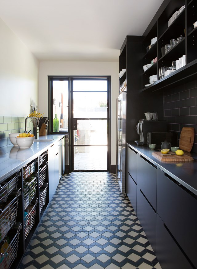 Design ideas for a contemporary galley kitchen pantry with flat-panel cabinets, porcelain floors, an undermount sink, black cabinets, black splashback, subway tile splashback, black appliances and blue floor.