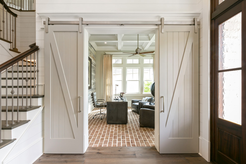 Inspiration for a beach style home office in Charleston with white walls, brick floors, a freestanding desk and red floor.