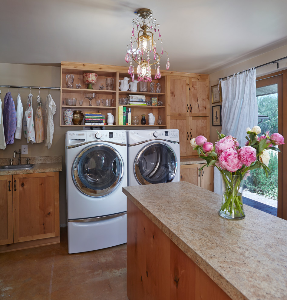 This is an example of a mid-sized country u-shaped utility room in Phoenix with a drop-in sink, flat-panel cabinets, beige walls, concrete floors and a side-by-side washer and dryer.