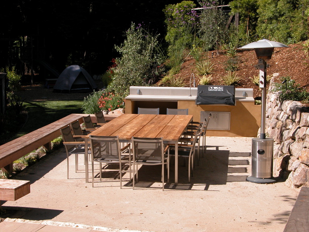 This is an example of a mid-sized modern backyard patio in San Francisco with an outdoor kitchen and decomposed granite.