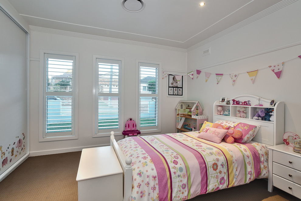 This is an example of a mid-sized traditional kids' bedroom for kids 4-10 years old and girls in Sydney with white walls, carpet and brown floor.