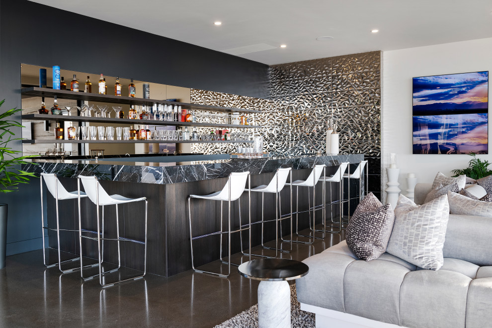 Стильный дизайн: огромный п-образный домашний бар в стиле модернизм с мойкой, зеркальным фартуком, серым полом и черной столешницей - последний тренд