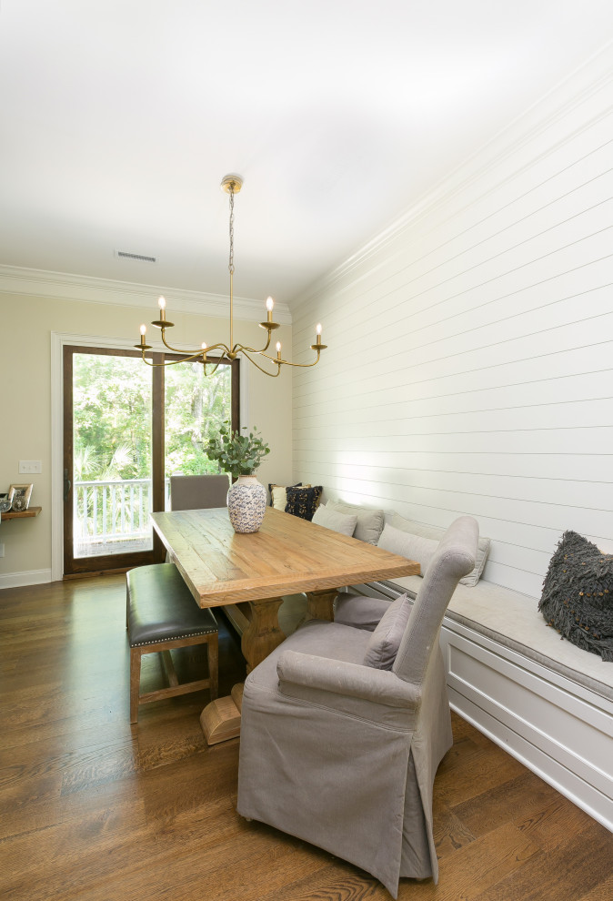 This is an example of a dining room in Charleston with white walls, medium hardwood floors and planked wall panelling.