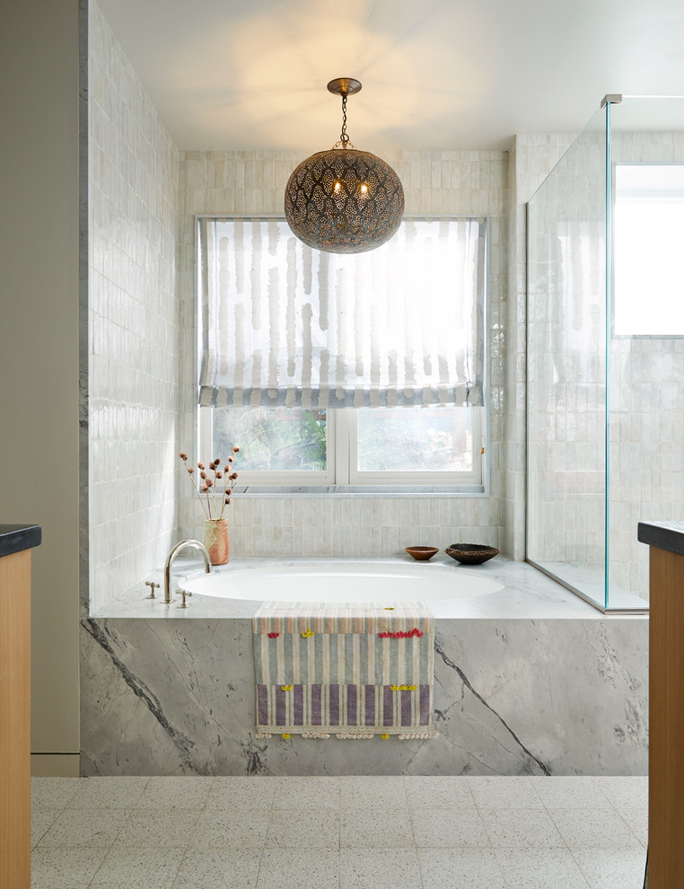 Scandinavian bathroom in San Francisco with flat-panel cabinets, light wood cabinets, a drop-in tub, white tile, white walls, ceramic floors, a drop-in sink, white floor, a hinged shower door and grey benchtops.