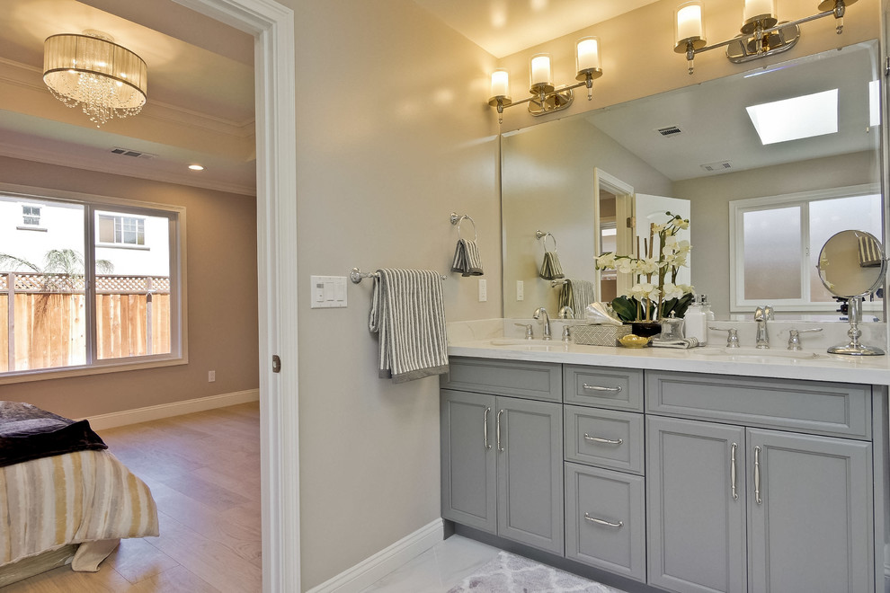 Mid-sized transitional master bathroom in San Francisco with recessed-panel cabinets, grey cabinets, a drop-in tub, a corner shower, gray tile, white tile, stone tile, grey walls, marble floors, an undermount sink and marble benchtops.