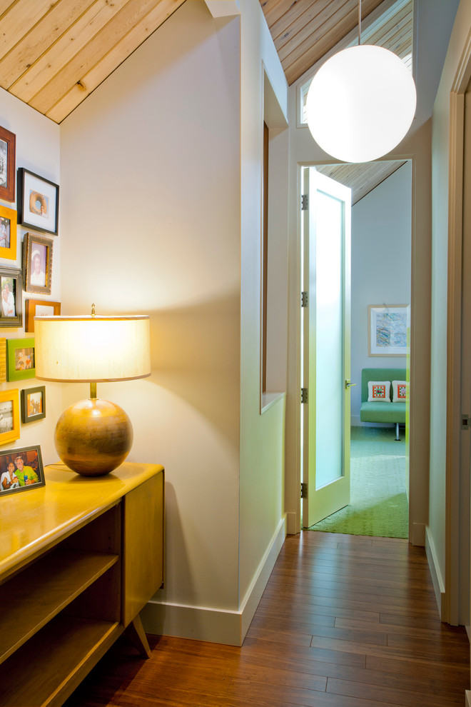 This is an example of a midcentury hallway in Portland with white walls and dark hardwood floors.