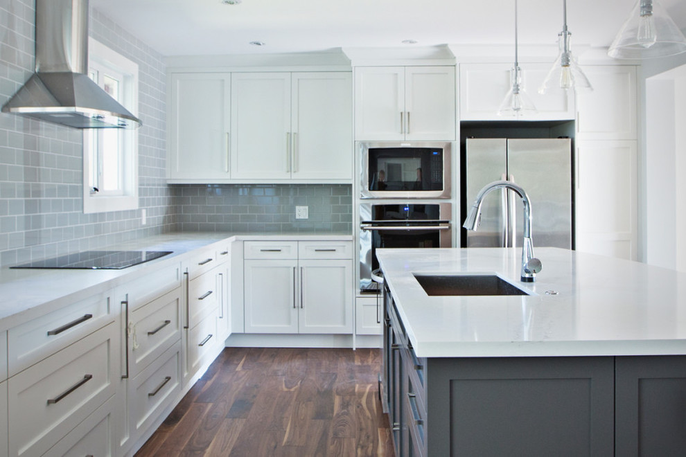 Inspiration for a large transitional l-shaped eat-in kitchen in Calgary with an undermount sink, recessed-panel cabinets, white cabinets, grey splashback, subway tile splashback, stainless steel appliances, dark hardwood floors, with island and quartz benchtops.