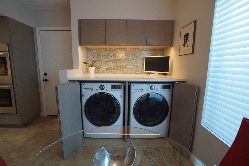 This is an example of a mid-sized contemporary single-wall laundry cupboard in Phoenix with flat-panel cabinets, grey cabinets, quartz benchtops, grey walls, a side-by-side washer and dryer and beige floor.