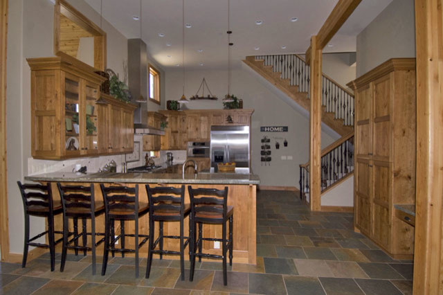 Inspiration for a mid-sized rustic u-shaped slate floor eat-in kitchen remodel in Orange County with beaded inset cabinets, light wood cabinets, granite countertops, white backsplash, ceramic backsplash, stainless steel appliances and a peninsula