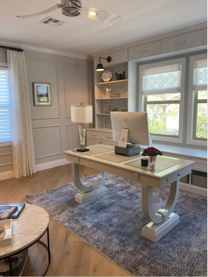 This is an example of a mid-sized transitional home office in Las Vegas with a library, grey walls, light hardwood floors, a freestanding desk, beige floor and wallpaper.