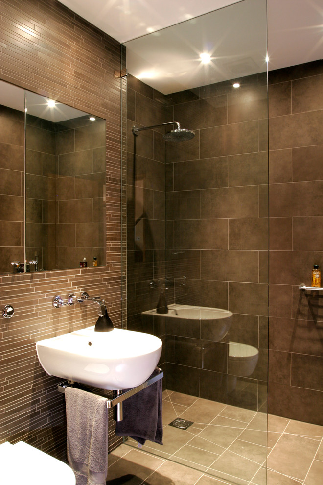 Contemporary 3/4 bathroom in London with a wall-mount sink, a corner shower, brown tile, matchstick tile and brown walls.