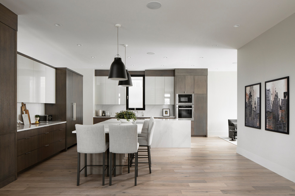 Kitchen - large modern l-shaped light wood floor kitchen idea in Calgary with a double-bowl sink, flat-panel cabinets, quartz countertops, quartz backsplash and an island