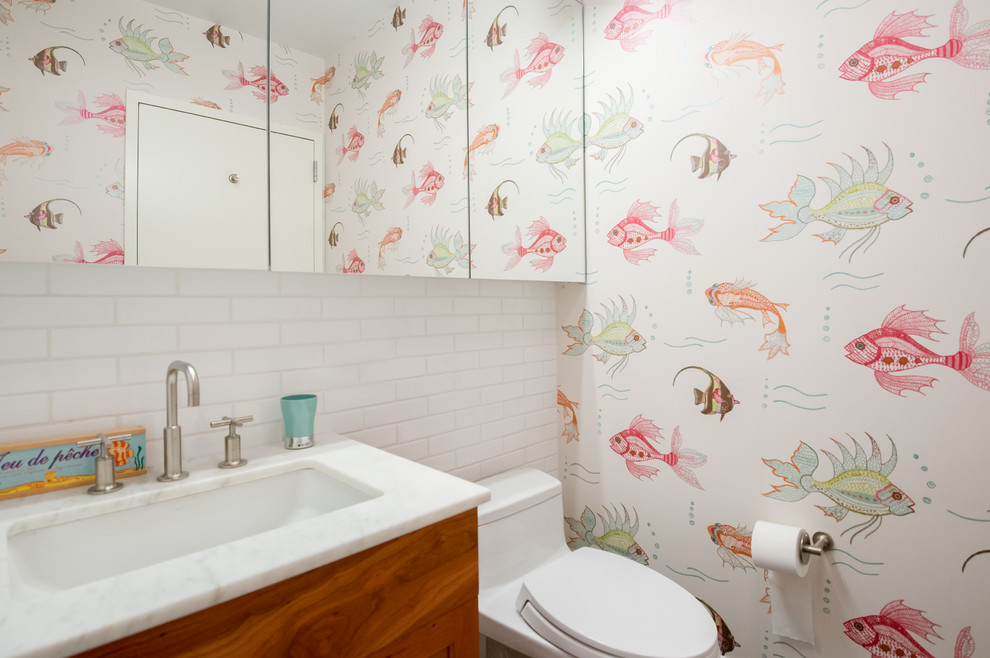 Small traditional kids bathroom in New York with medium wood cabinets, a one-piece toilet, multi-coloured walls, flat-panel cabinets, white tile, subway tile, an undermount sink and marble benchtops.