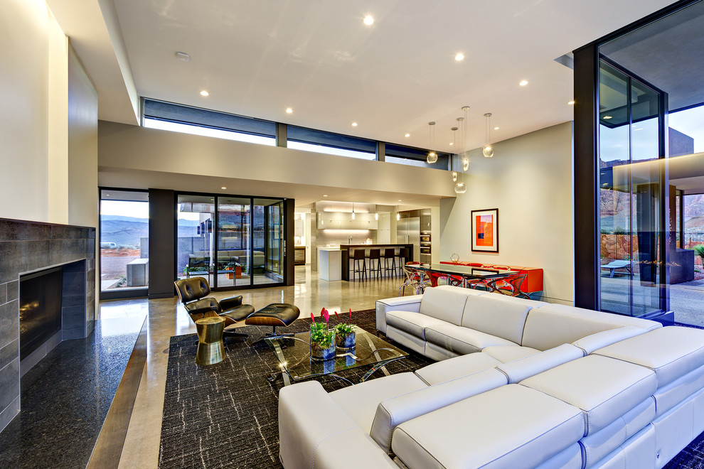 This is an example of a mid-sized contemporary formal open concept living room in Salt Lake City with beige walls, concrete floors, grey floor, a tile fireplace surround, no fireplace and no tv.