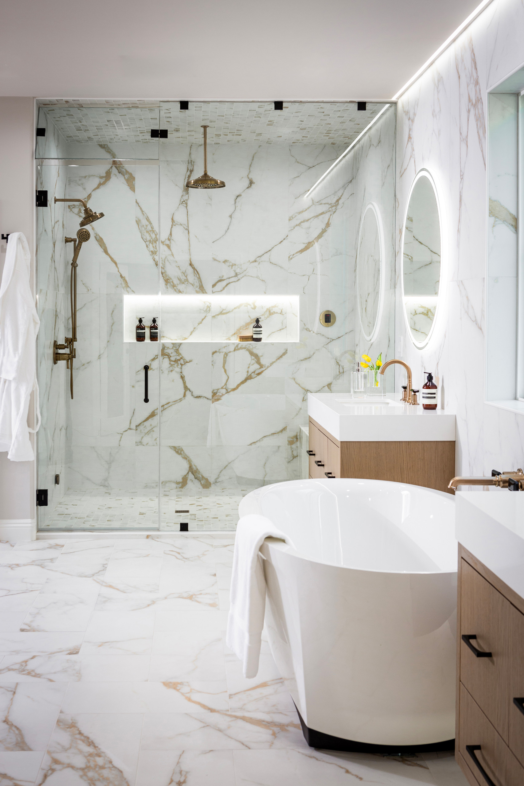 Example of a white tile white marble floor and double-sink bathroom design in Los Angeles with flat-panel cabinets, white oak wood cabinets, marble walls, an undermount sink, a hinged shower door
