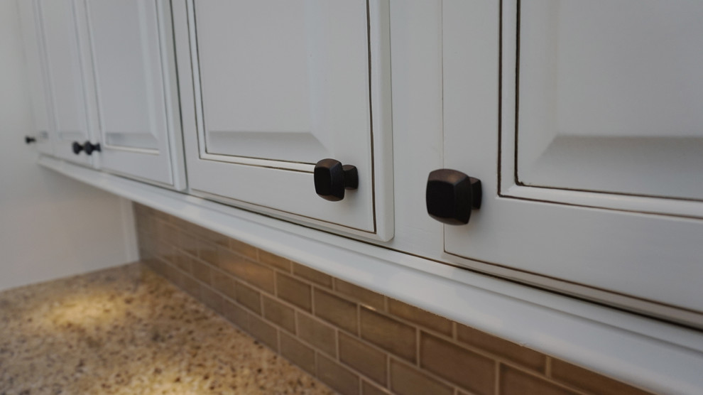 Eat-in kitchen - large transitional u-shaped medium tone wood floor eat-in kitchen idea in Atlanta with an undermount sink, raised-panel cabinets, white cabinets, granite countertops, gray backsplash, ceramic backsplash, stainless steel appliances and an island