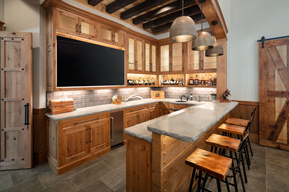 Design ideas for a country u-shaped seated home bar in Atlanta with an undermount sink, raised-panel cabinets, medium wood cabinets, grey splashback, grey floor and grey benchtop.