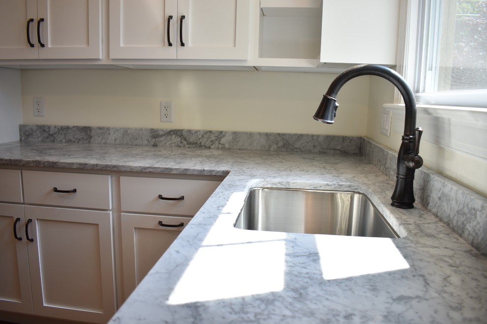 Home design - mid-sized transitional u-shaped medium tone wood floor and brown floor home design idea with an undermount sink, recessed-panel cabinets, white cabinets, marble countertops, stainless steel appliances, no island and multicolored countertops
