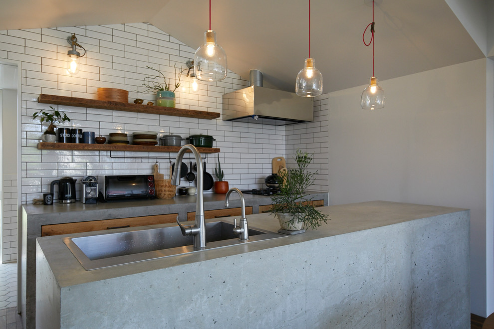 Design ideas for an industrial galley kitchen in Other with a single-bowl sink, flat-panel cabinets, medium wood cabinets, concrete benchtops, white splashback and with island.