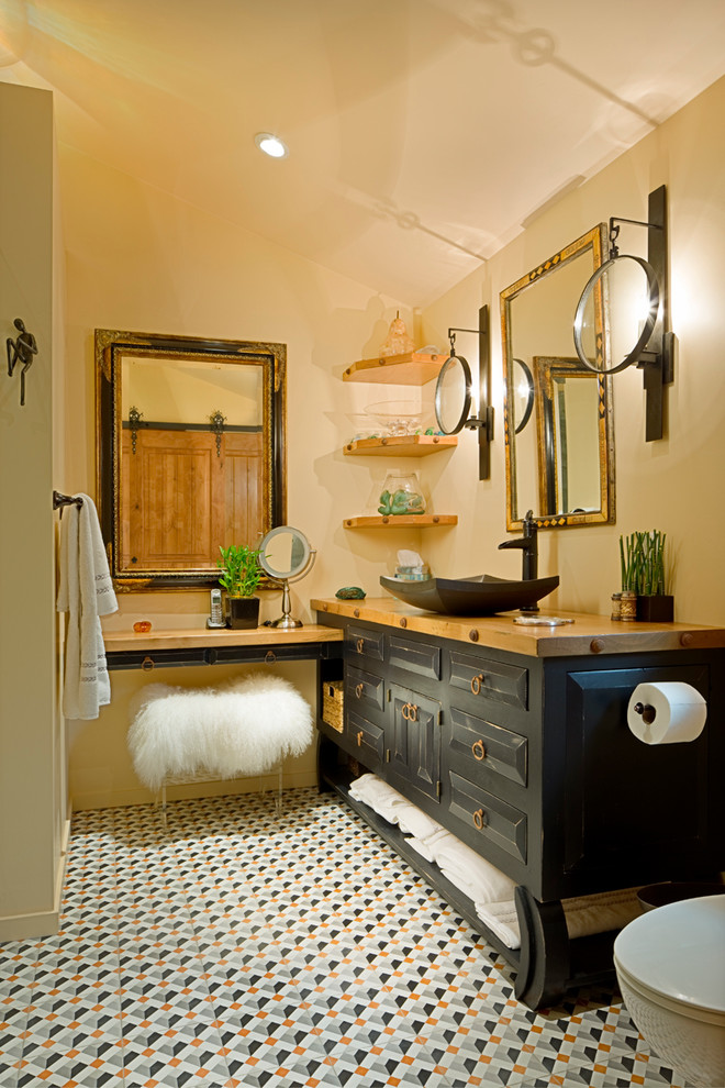 Photo of a mid-sized transitional master bathroom in Other with an alcove shower, beige walls, raised-panel cabinets, black cabinets, a one-piece toilet, porcelain floors, a vessel sink, wood benchtops and multi-coloured floor.
