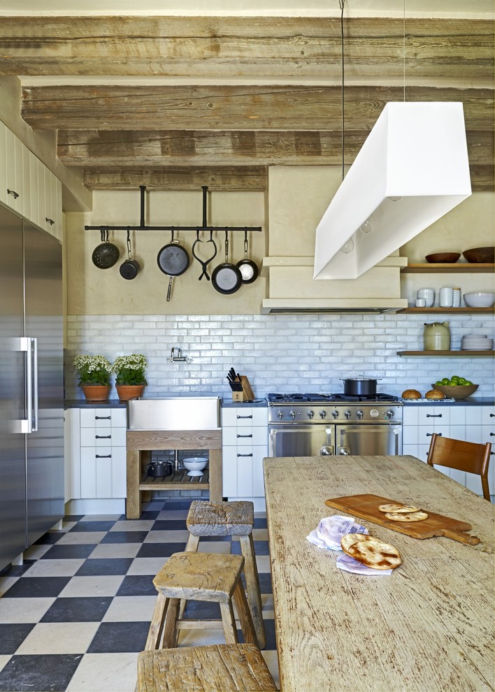 Photo of a mediterranean kitchen in Phoenix with a farmhouse sink and stainless steel appliances.