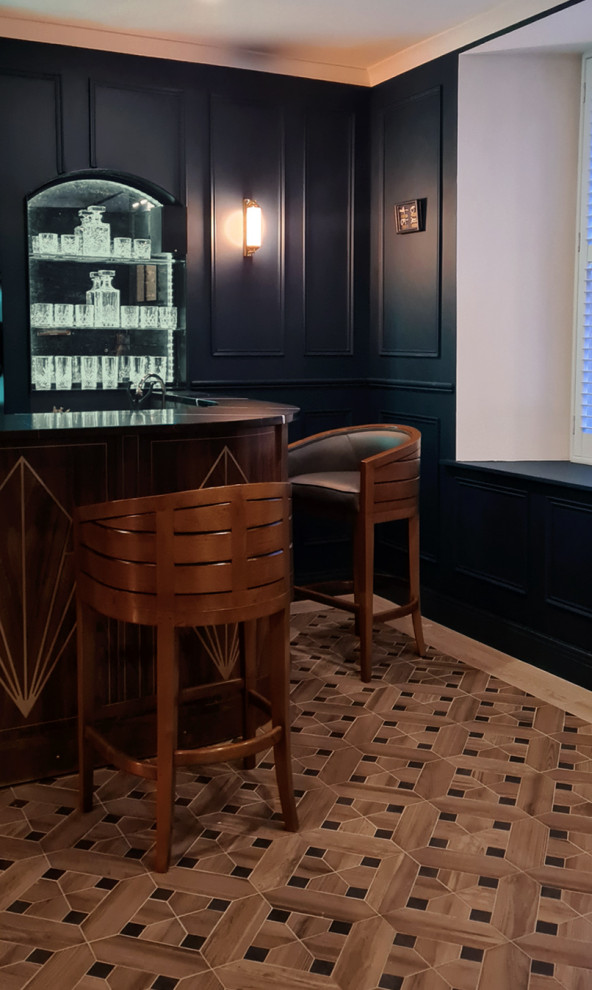 Large midcentury u-shaped home bar in Dublin with a drop-in sink, medium wood cabinets, copper benchtops, black splashback, porcelain floors, multi-coloured floor and black benchtop.