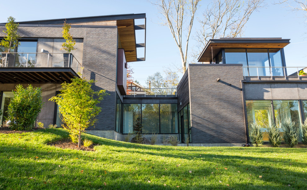 Zweistöckiges Modernes Einfamilienhaus mit Backsteinfassade, schwarzer Fassadenfarbe und Schmetterlingsdach in Cincinnati