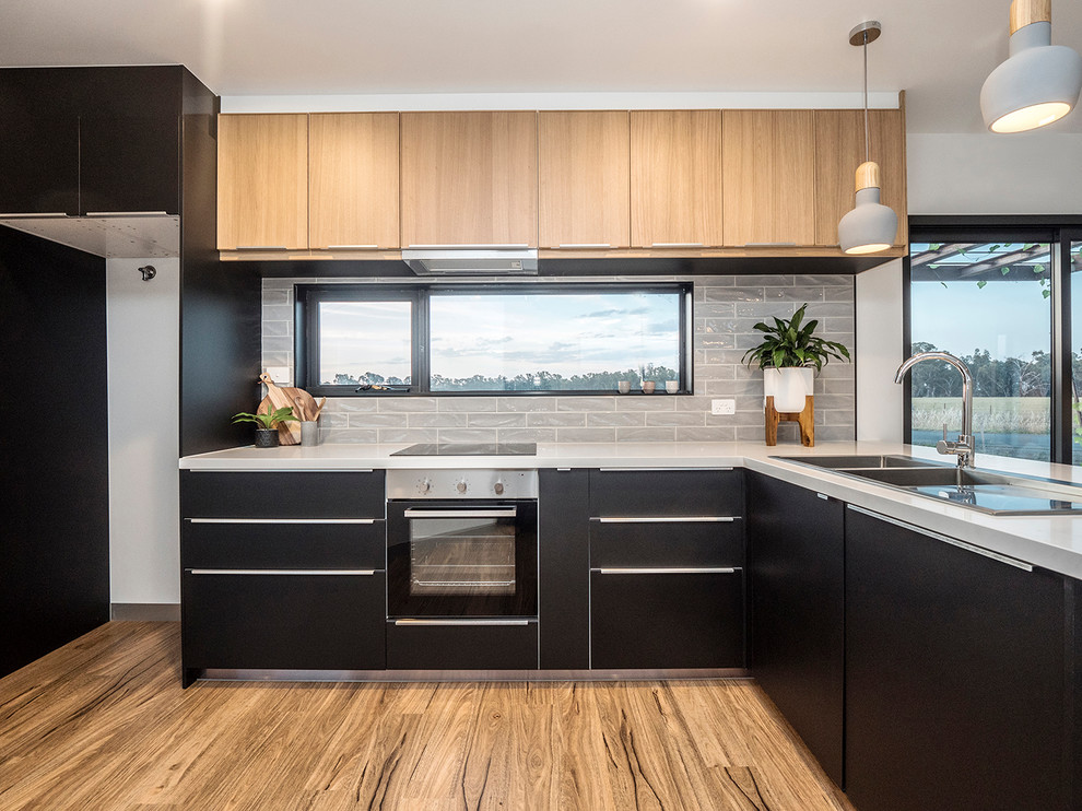 Inspiration for a small contemporary l-shaped open plan kitchen in Other with black cabinets, grey splashback, ceramic splashback, stainless steel appliances and vinyl floors.