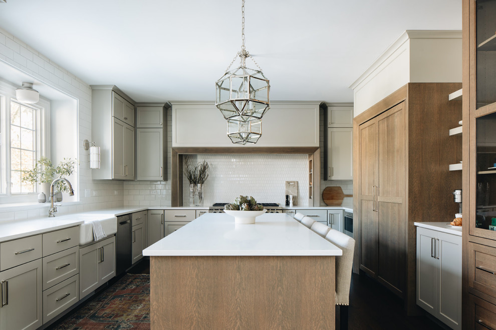 Mid-sized transitional dark wood floor eat-in kitchen photo in Chicago with a farmhouse sink, shaker cabinets, gray cabinets, quartz countertops, white backsplash, ceramic backsplash, paneled appliances, an island and white countertops