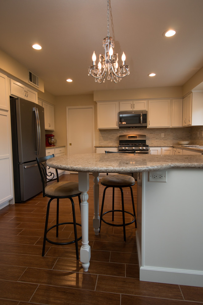 Example of a mid-sized transitional u-shaped porcelain tile open concept kitchen design with an undermount sink, recessed-panel cabinets, beige cabinets, quartz countertops, beige backsplash, mosaic tile backsplash and colored appliances