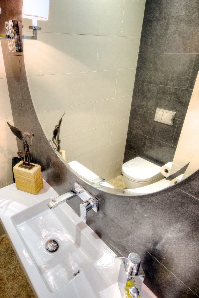 Photo of a contemporary bathroom in Sydney with a one-piece toilet, gray tile, white tile, cement tile, multi-coloured walls, travertine floors and an integrated sink.