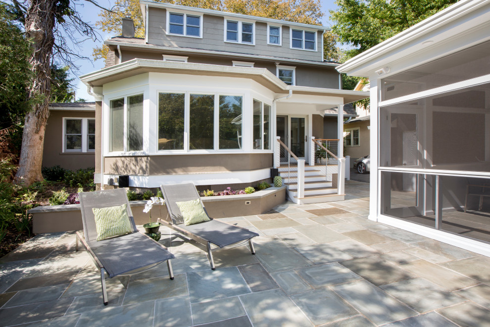 Small modern back patio in New York with natural stone paving and a roof extension.
